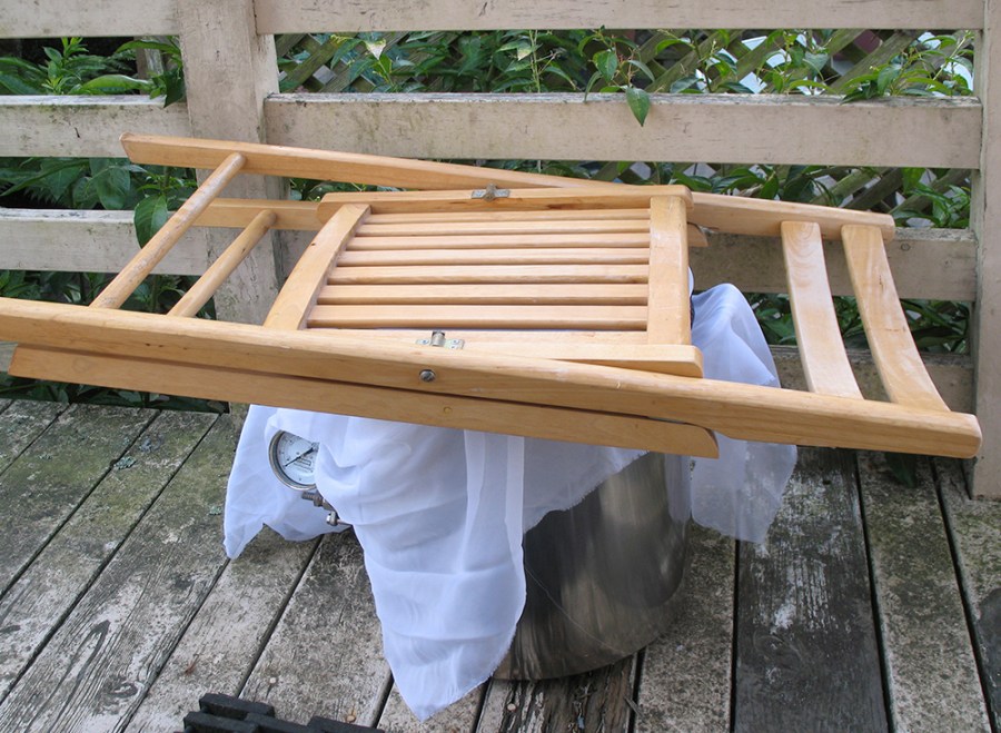 Back porch coolship: For this batch I used the kettle itself as the coolship to let the wort cool slowly and attract wild yeasts. I used a mesh bag to let bacteria and wild yeast in but keep flies out, and the chair to thwart neighborhood raccoons. Overnight in the winter months gets cold enough.