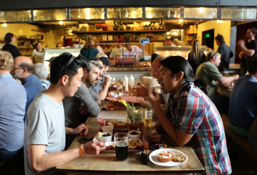 Long common tables and a retro kitchen behind