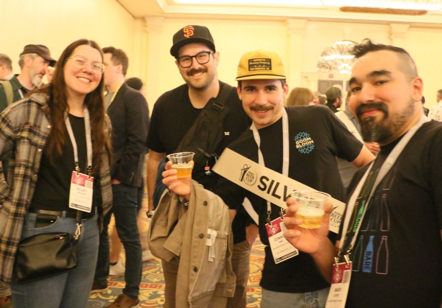 Head brewer Kelsey Holstein and members of the BareBottle Brewing crew stand with beers at the after-awards reception